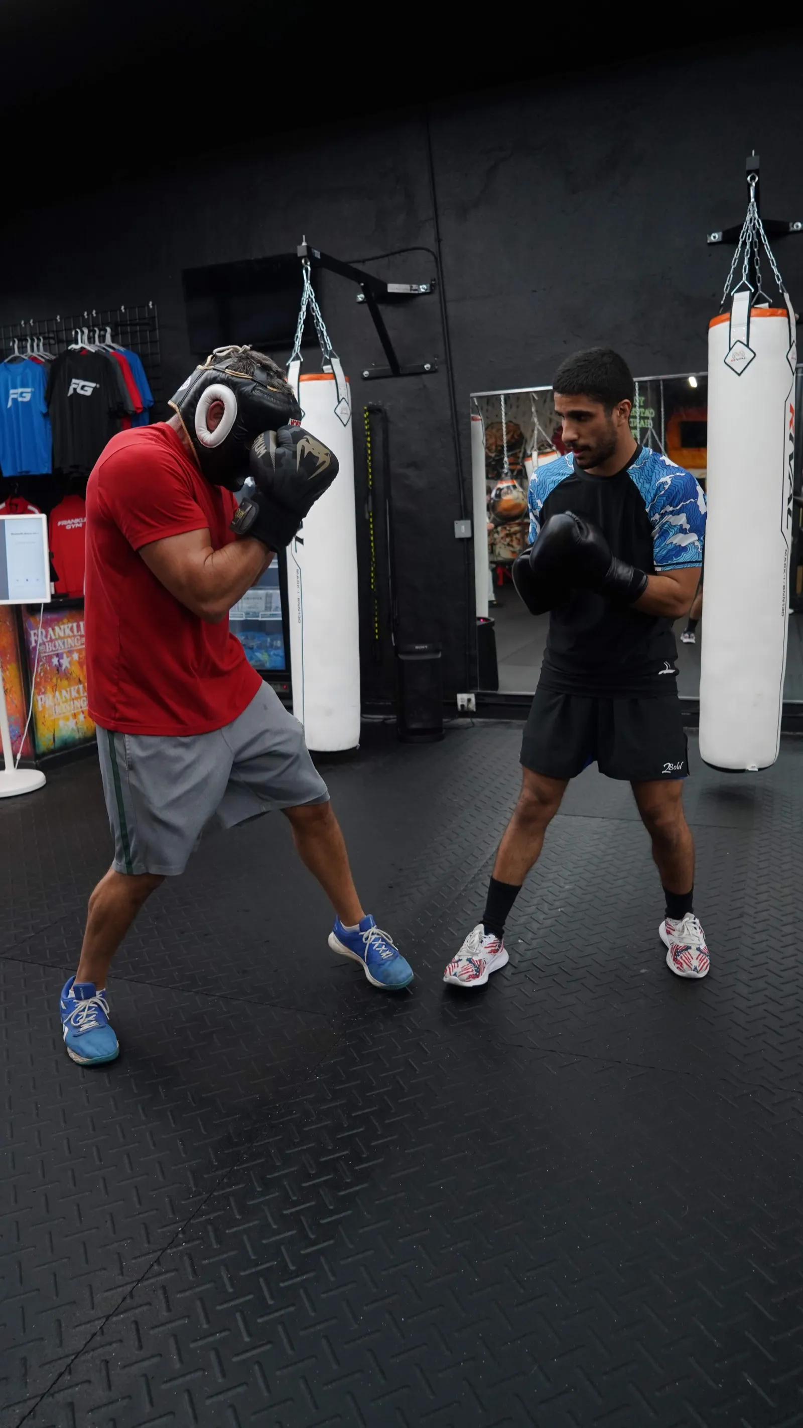 Partner drills in front of the mirrors and RIVAL heavy bags