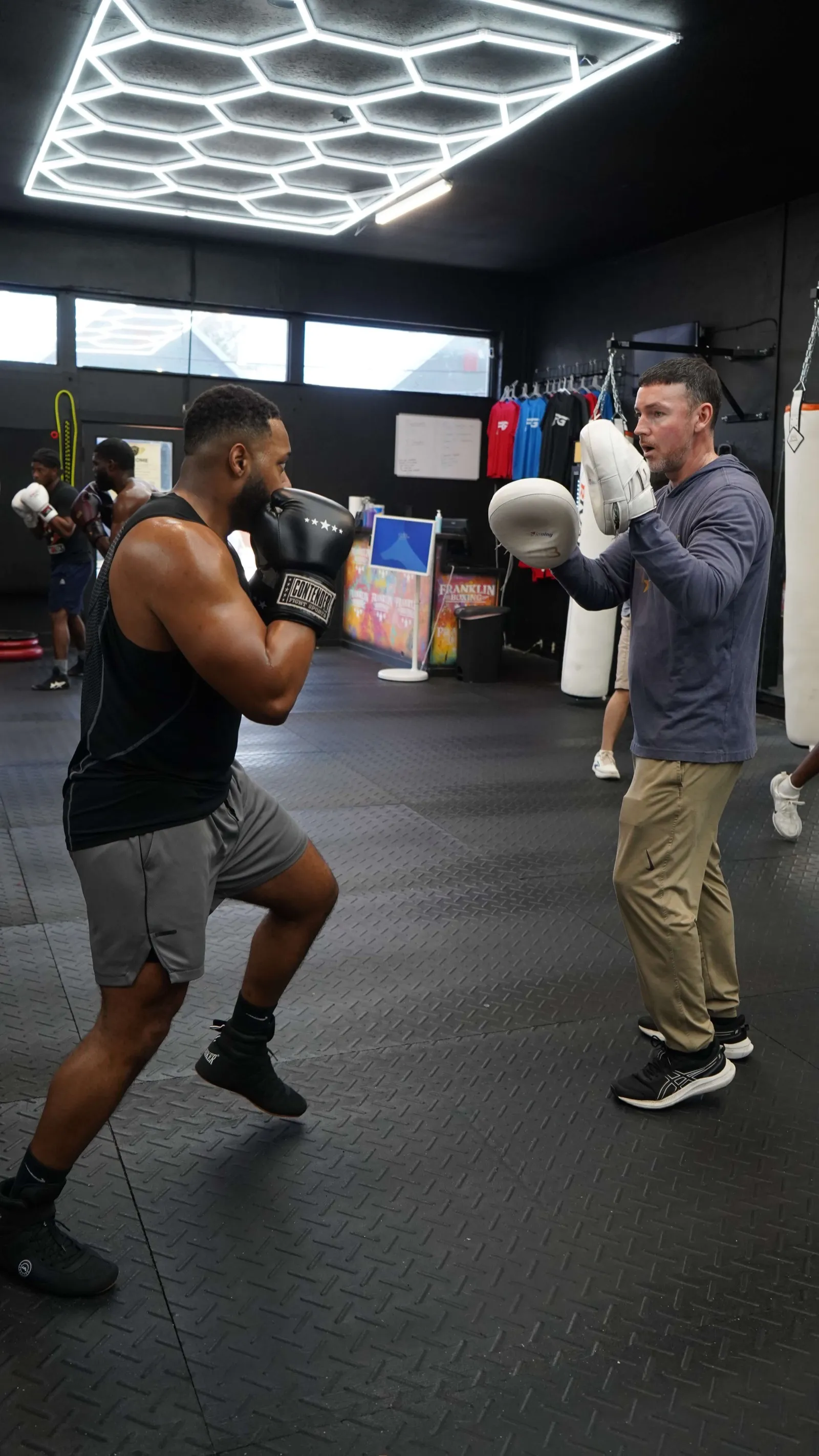 One-on-one mitt work with a coach under the honeycomb lights