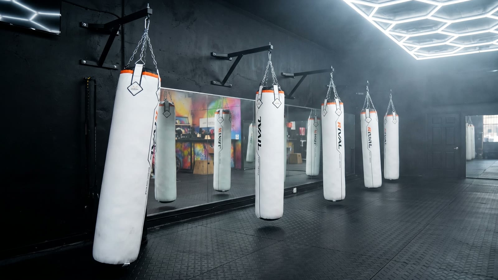 A row of white heavy bags hanging on chains inside Franklin Gym